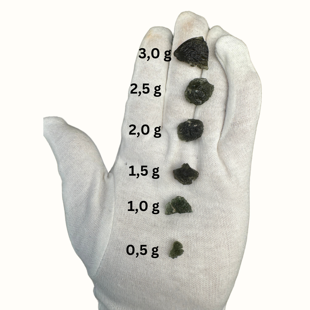 Hand in Handschuh mit verschiedenen Moldaviten aus Tschechien in verschiedenen Größen